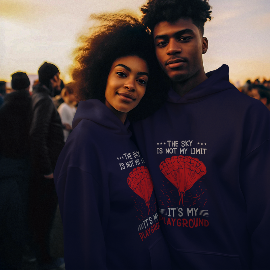 Adventurous couple embraces the sky's vastness in matching navy hoodies, themed as 'The sky is not my limit, it's my playground