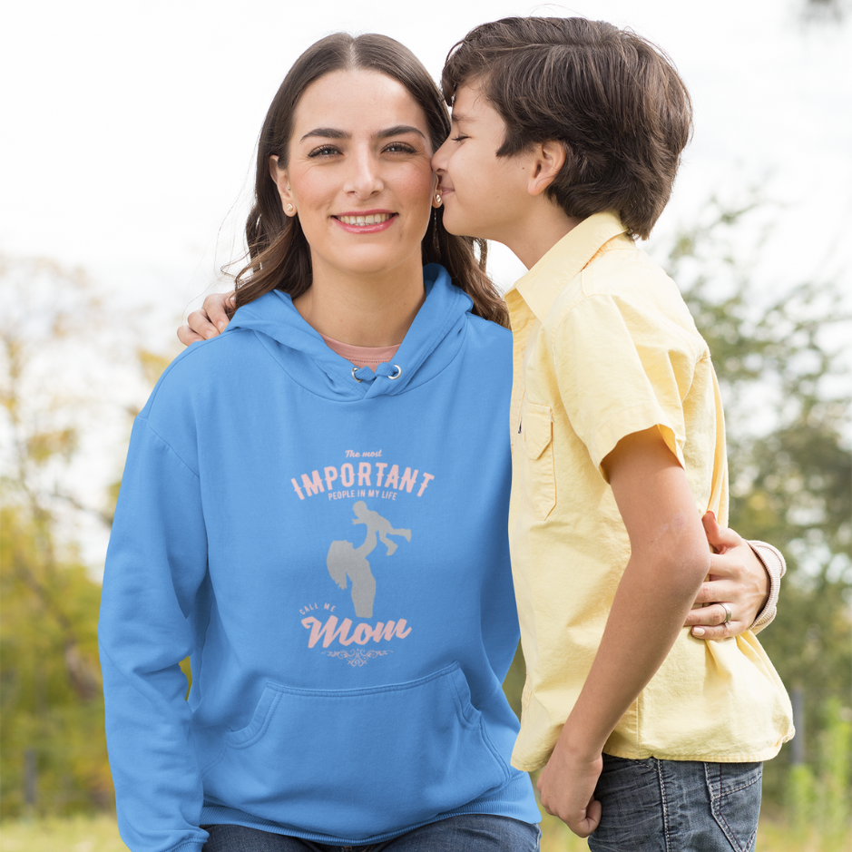 A mother, clad in a carolina blue hoodie with the inscription 'The most important people in my life, they call me mom,' walks alongside her son on a serene journey, epitomizing the essence of maternal love and devotion